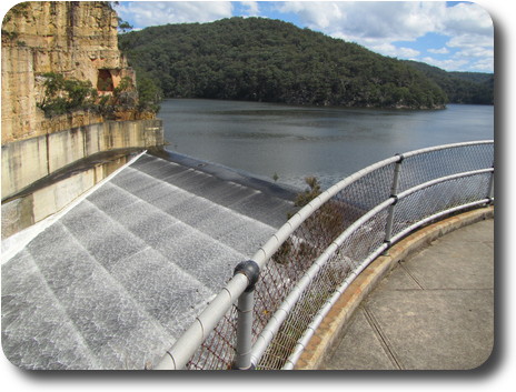 Water flowing over spillway lip and down past the dam