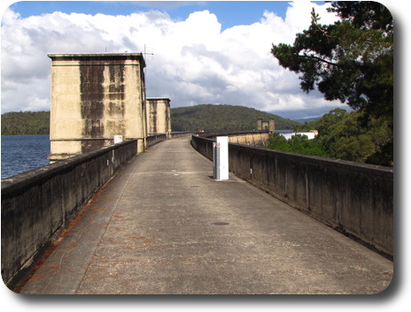 Curving dam wall, 2 cement towers and cascading spillway at far end