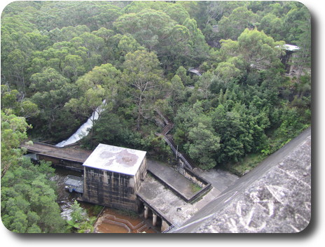 Cement buildings and water channel among lush forest