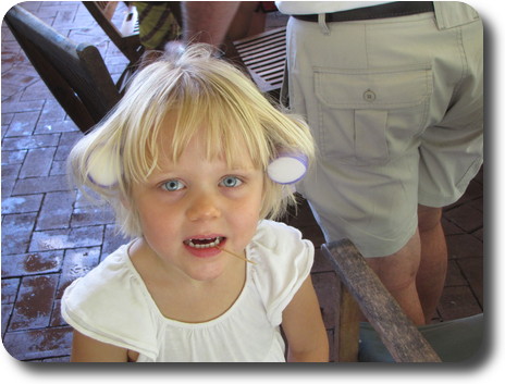 Little girl with her hair in rollers, toothpick in her mouth