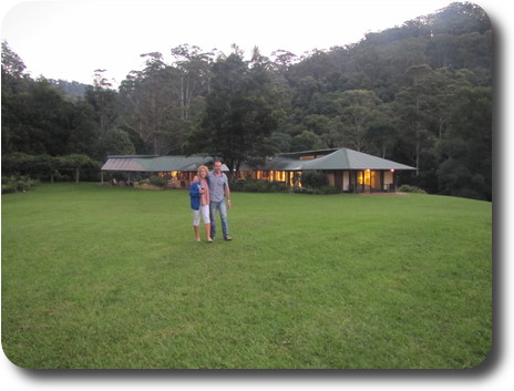 Man and woman strolling on lawn in front of house