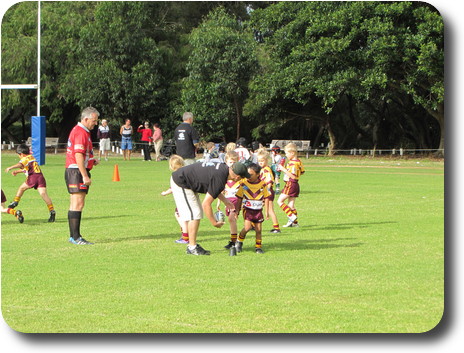 Man instructing little boy on kicking the ball