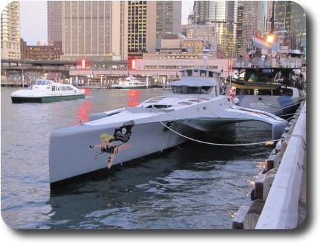 Sleek, gray painted trimaran tied up at the wharf