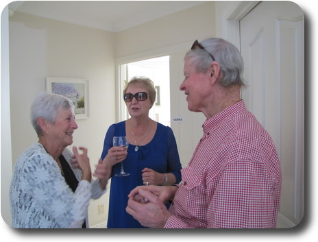 Two women and a man in conversation inside