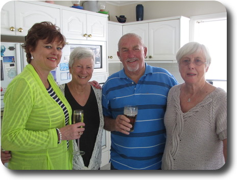 Three women and a man together in the kitchen