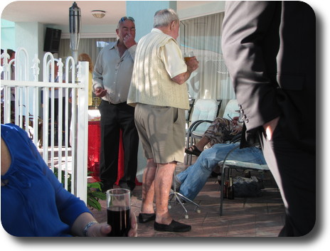 Man with four footed walking stick talking to others