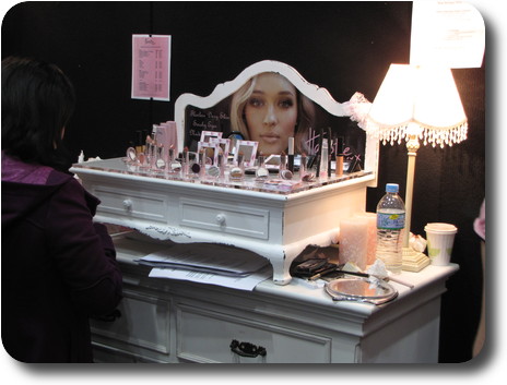 White wooden table with cosmetics products atop a white wooden dresser