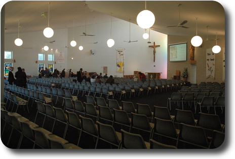 Interior of church, showing empty seats, choir at far side