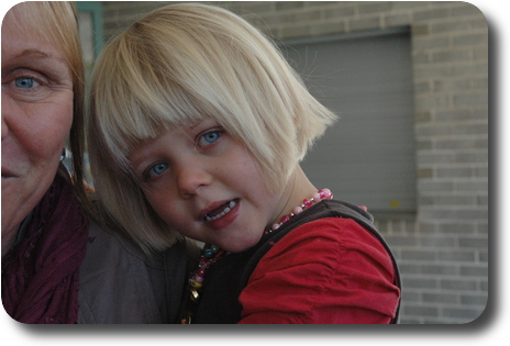 Little girl, cuddled on her mum's shoulder