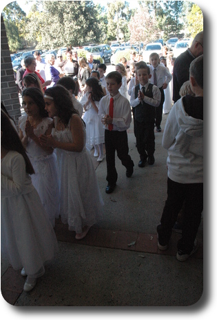 Boys and girls lined up in pairs, waiting to enter the church