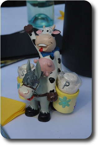 Waving cow riding a donkey carrying salt and pepper shakers