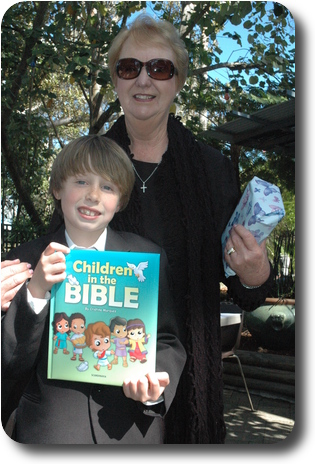 Boy holding book with his grandmother