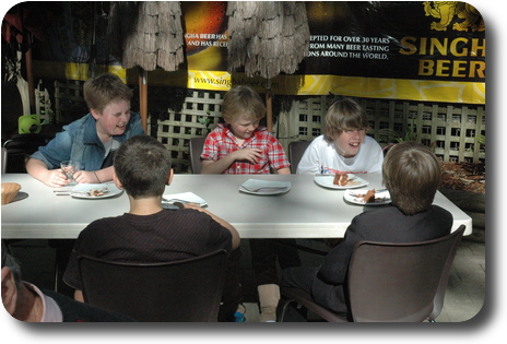 Five boys sitting at table in restaurant garden