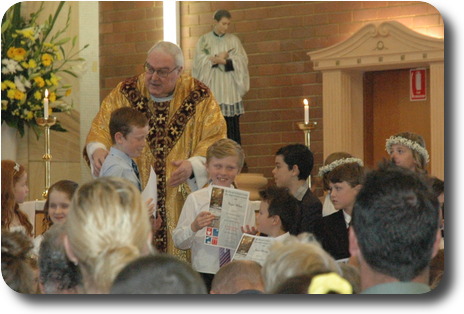 Youngsters standing at front of altar having received their certificate