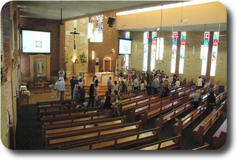 Church building from stairs to balcony, with people milling around thefront taking photos