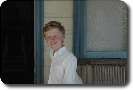 Boy in white shirt looking sideways into camera