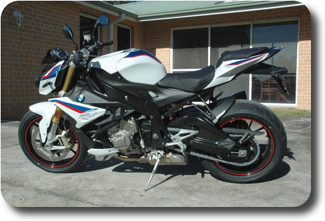 Left side view of white, blue red motorcycle, black frame