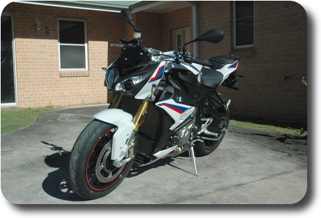 Left front side view of white, blue red motorcycle, black frame