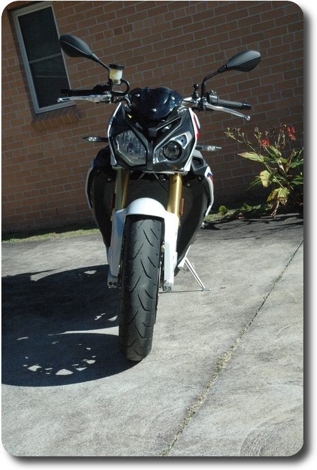 Front view of white, blue red motorcycle, black frame