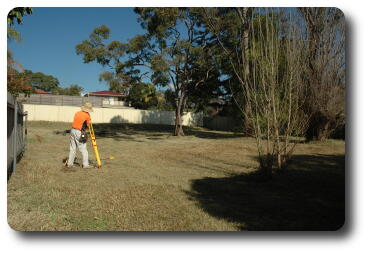 From driveway, looking south, with surveyor at work