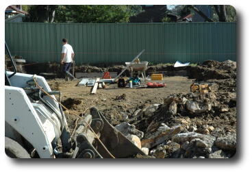 Work site with worker and tools, looking west