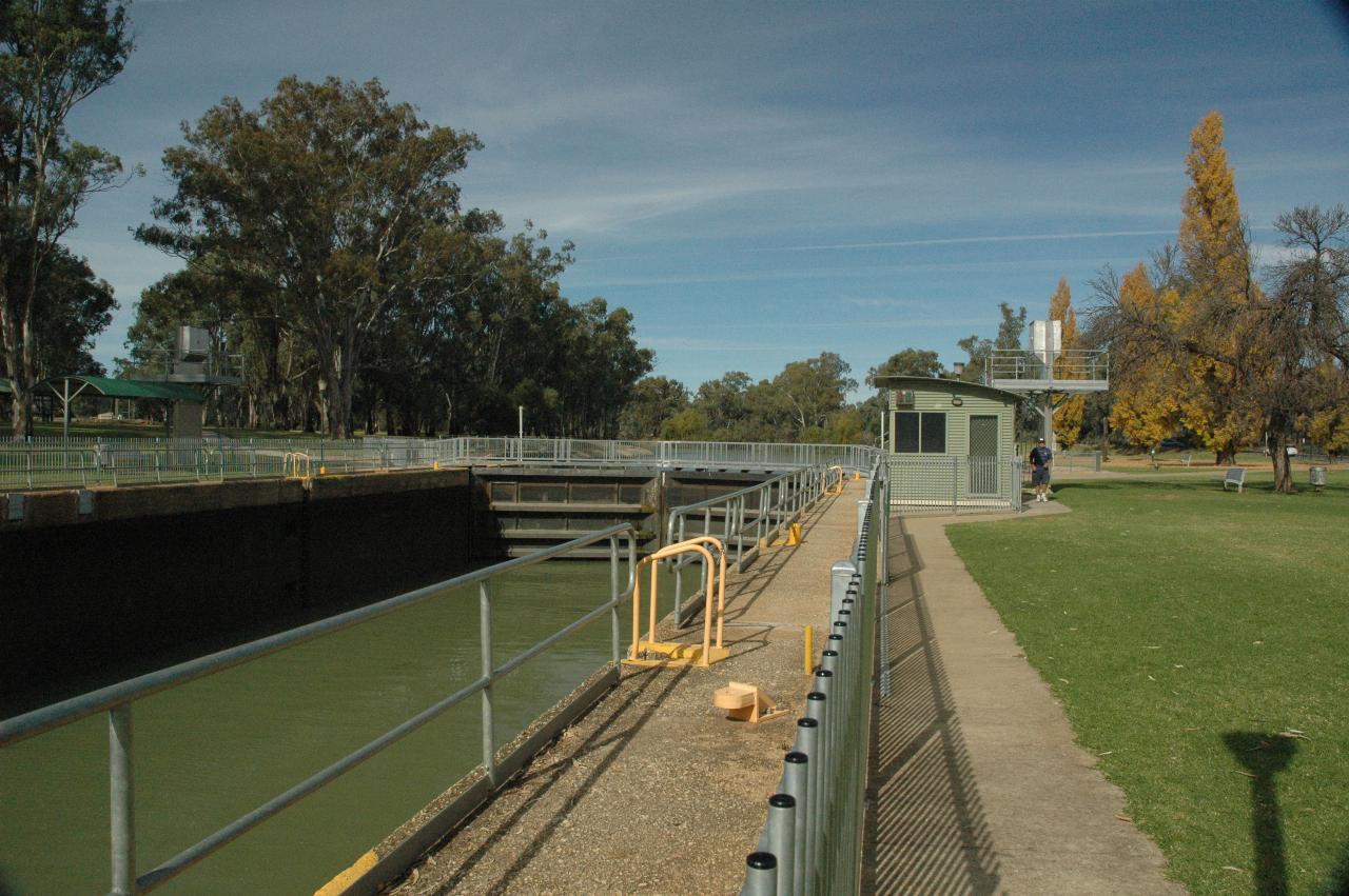 Concrete lock with low water level, upstream gates closed, and control cabin of green metal