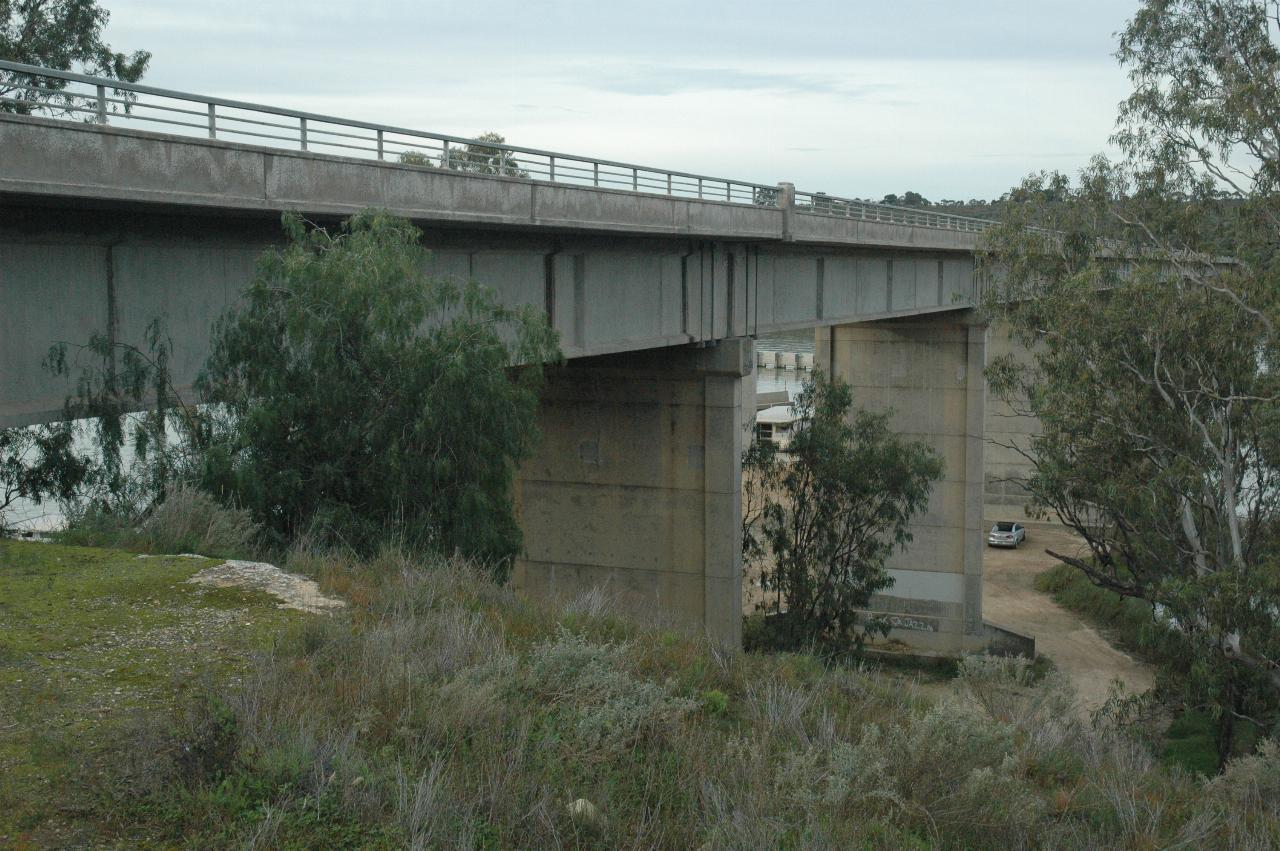 View from side looking along concrete bridge, slight view of river below