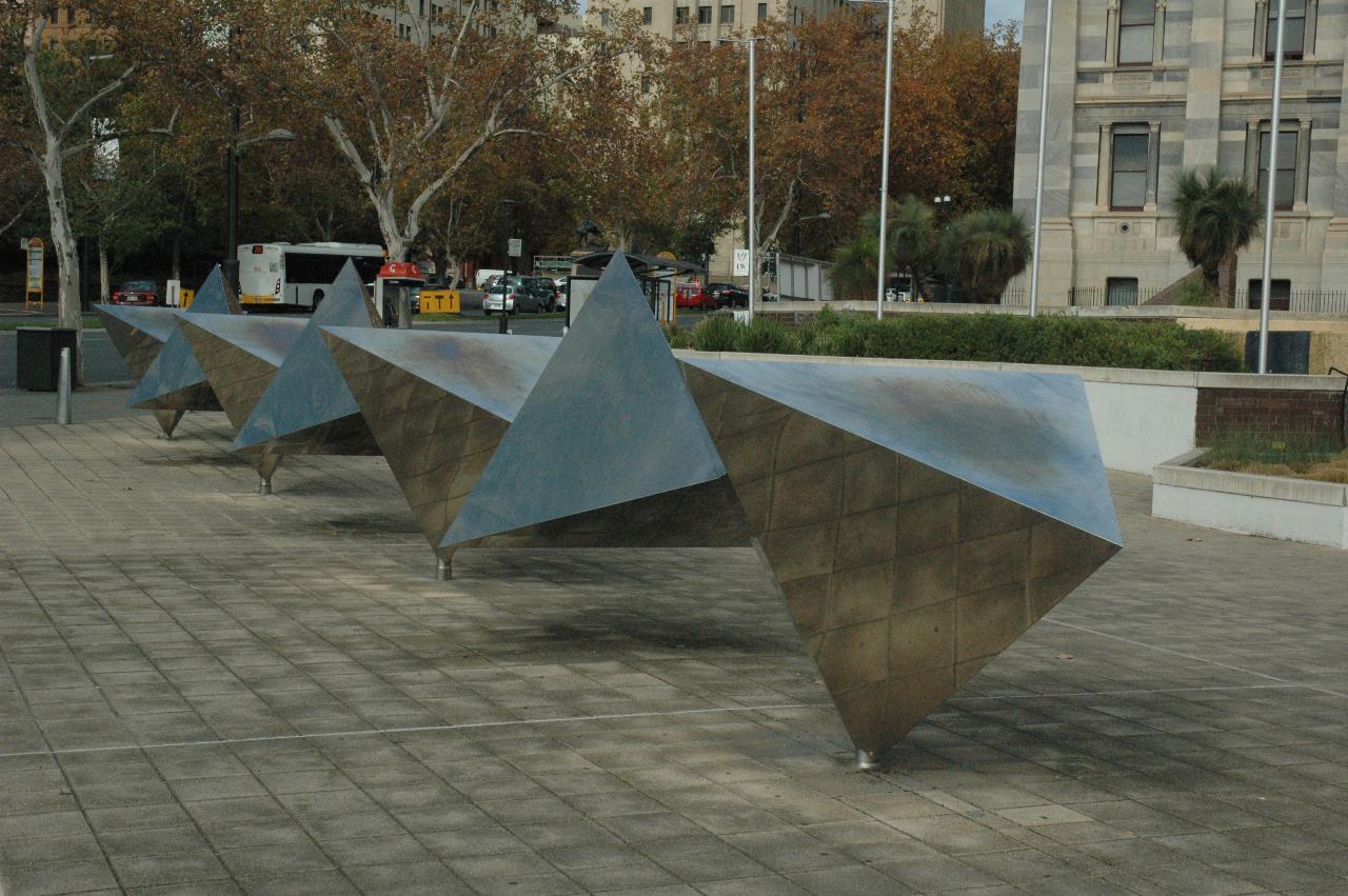 Stainless steel pyramid shapes joined together running horizontally