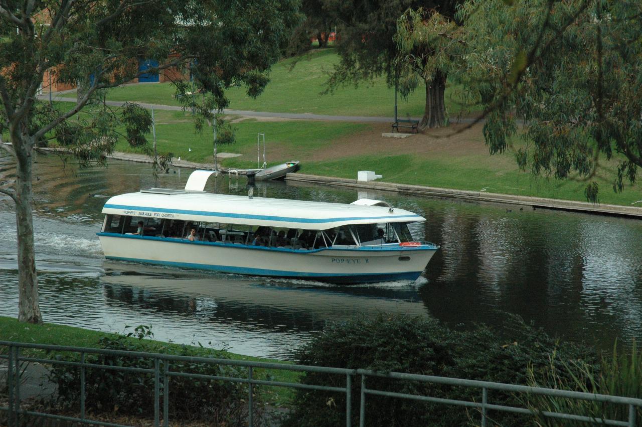 White with blue trim tourist motor vessel on the river