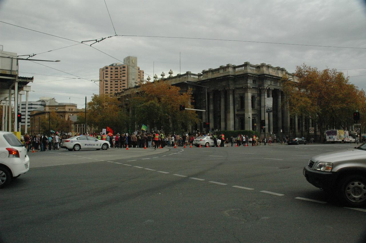 Intersection with exit blocked, and crowd of people in front of columned building