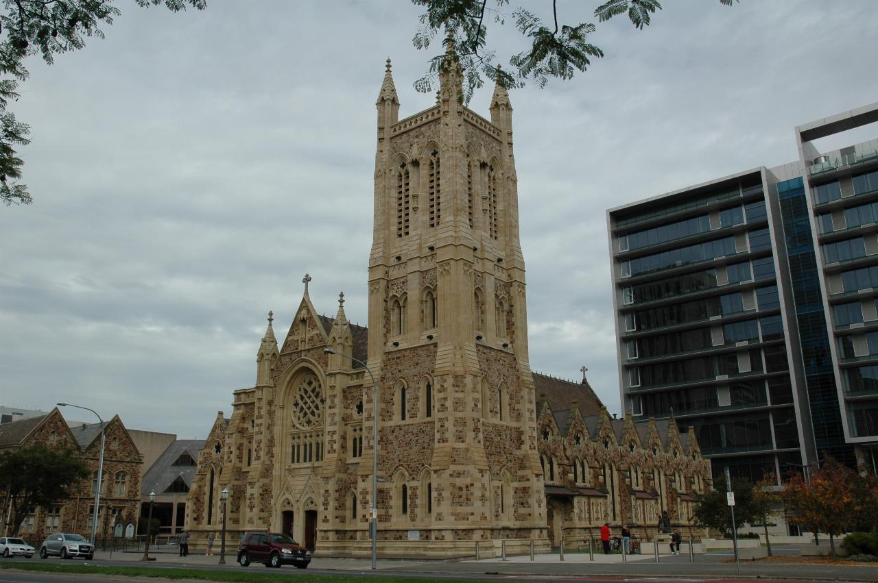 Stone church, with tower, in front of modern 10 storey building