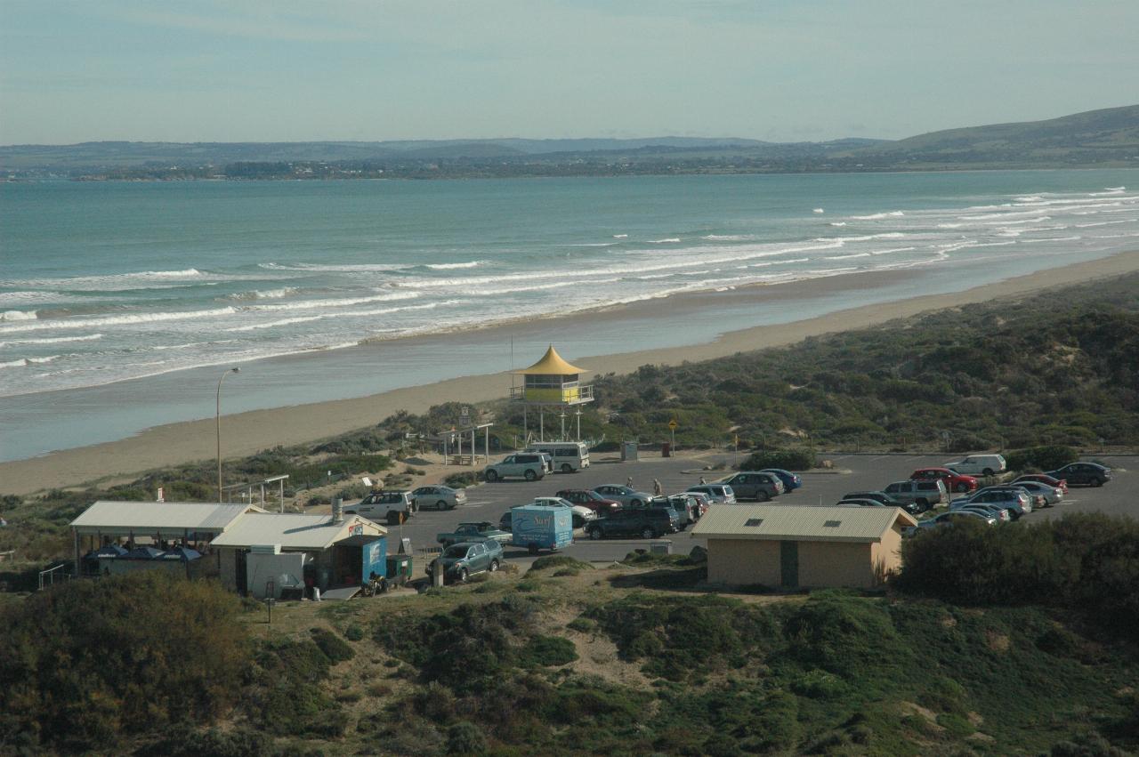 Up high view of beack, waves, car park and lifeguard tower and other facilities