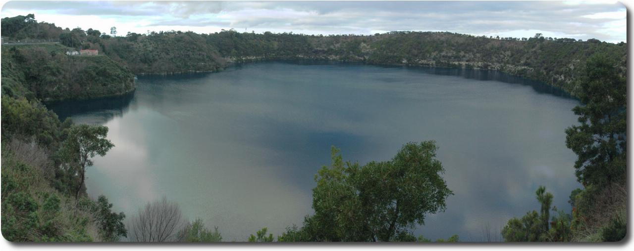 Volcanic crater with water, somewhat blue but reflecting grey clouds