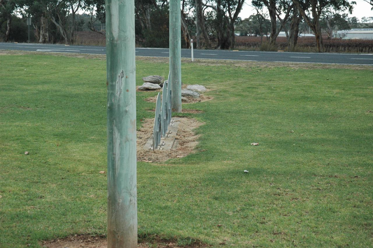 Two wooden poles with something thin between them, on the ground and standing up