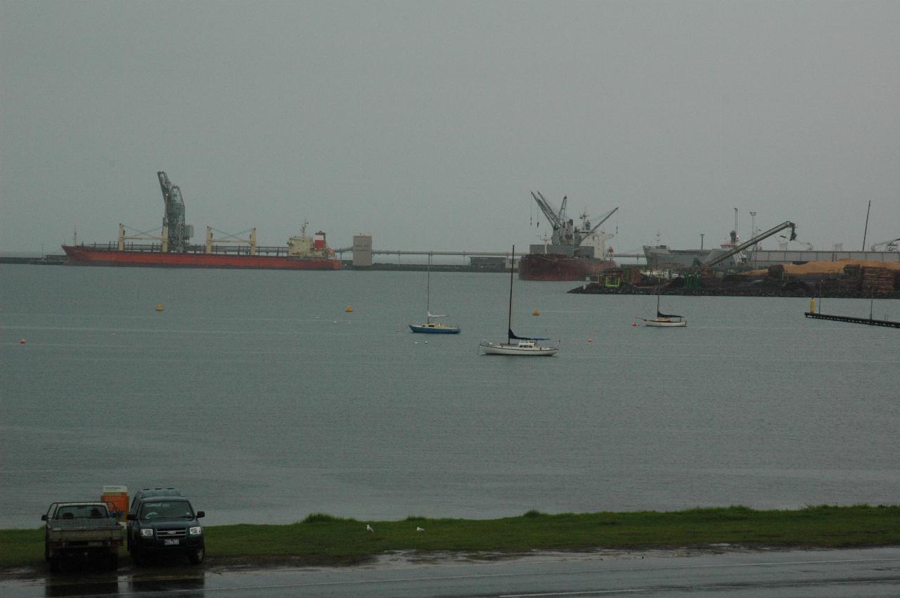 Several ships at docks with loading cranes and gantries
