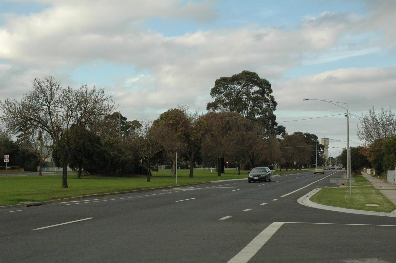 Four lane divided road, with very wide median strip with grass and trees