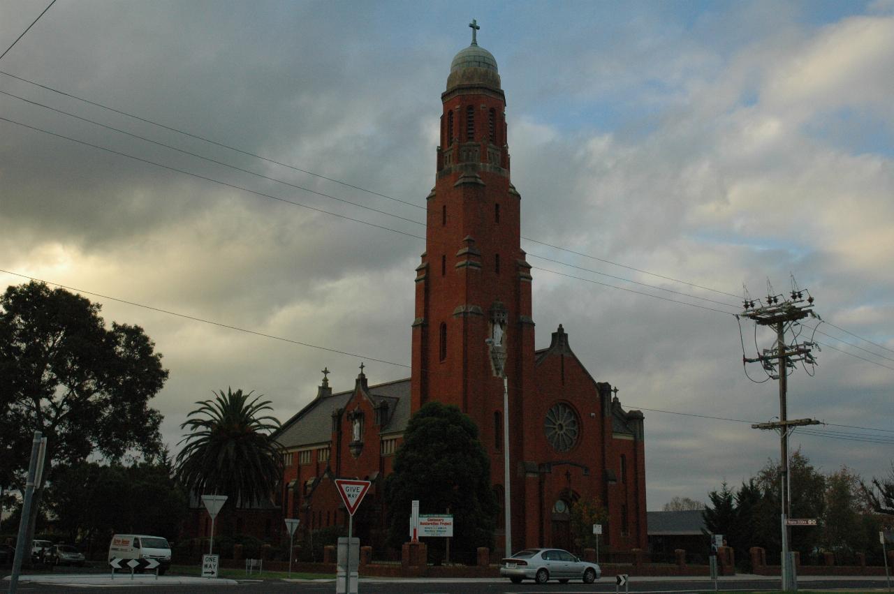 Red brick church building with very tall tower and dome on top