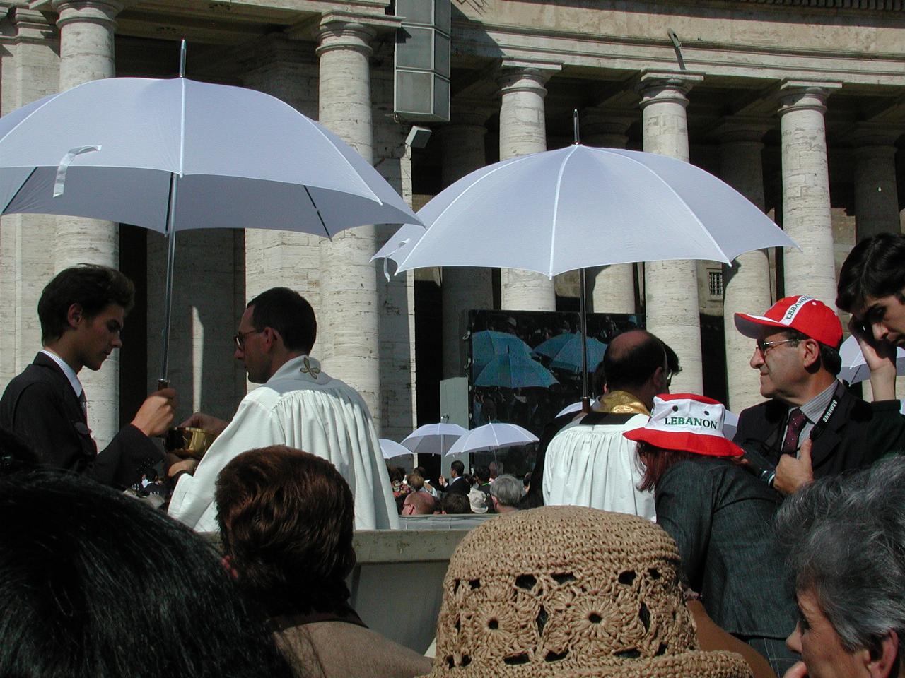 Priests and white umbrellas again for Communion