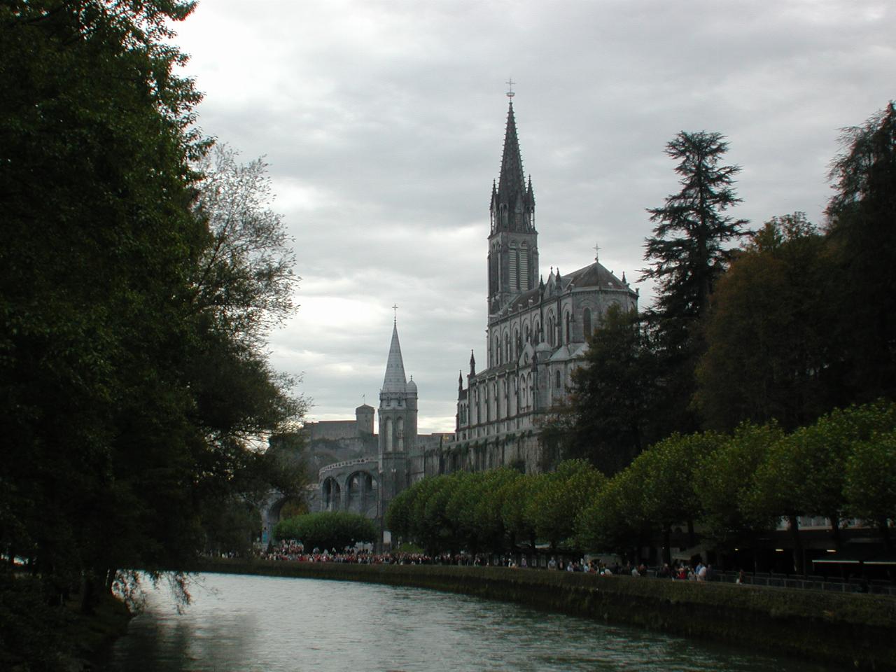 Lourdes Cathedral with view to distant hill top castle