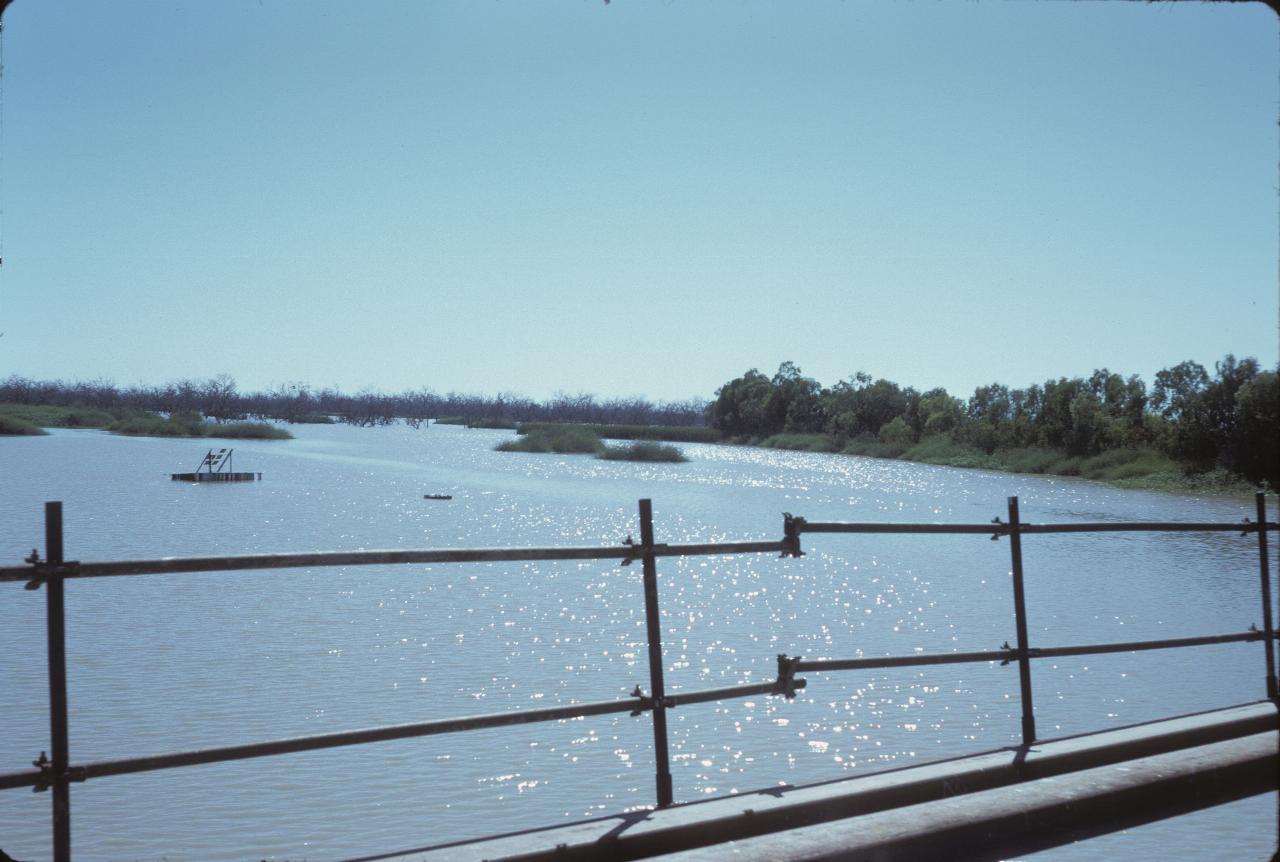 Upstream view from dam wall, with little islands and pontoon in the water