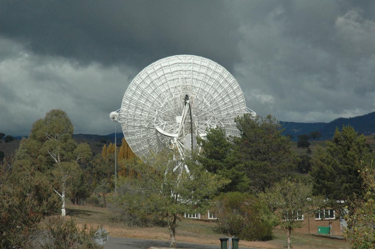 Photo of large tracking dish, underneath to camera, facing distant horizon