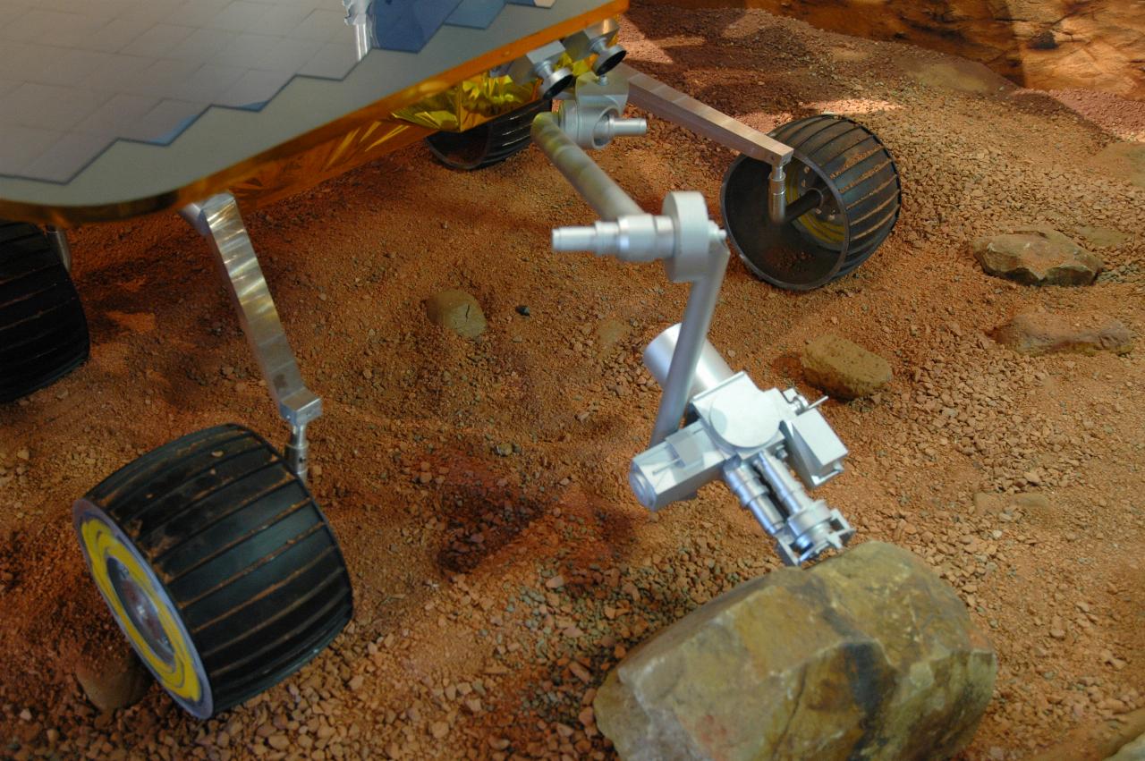 Mars rover in display of simulated surface of Mars; front view of manipulator arm