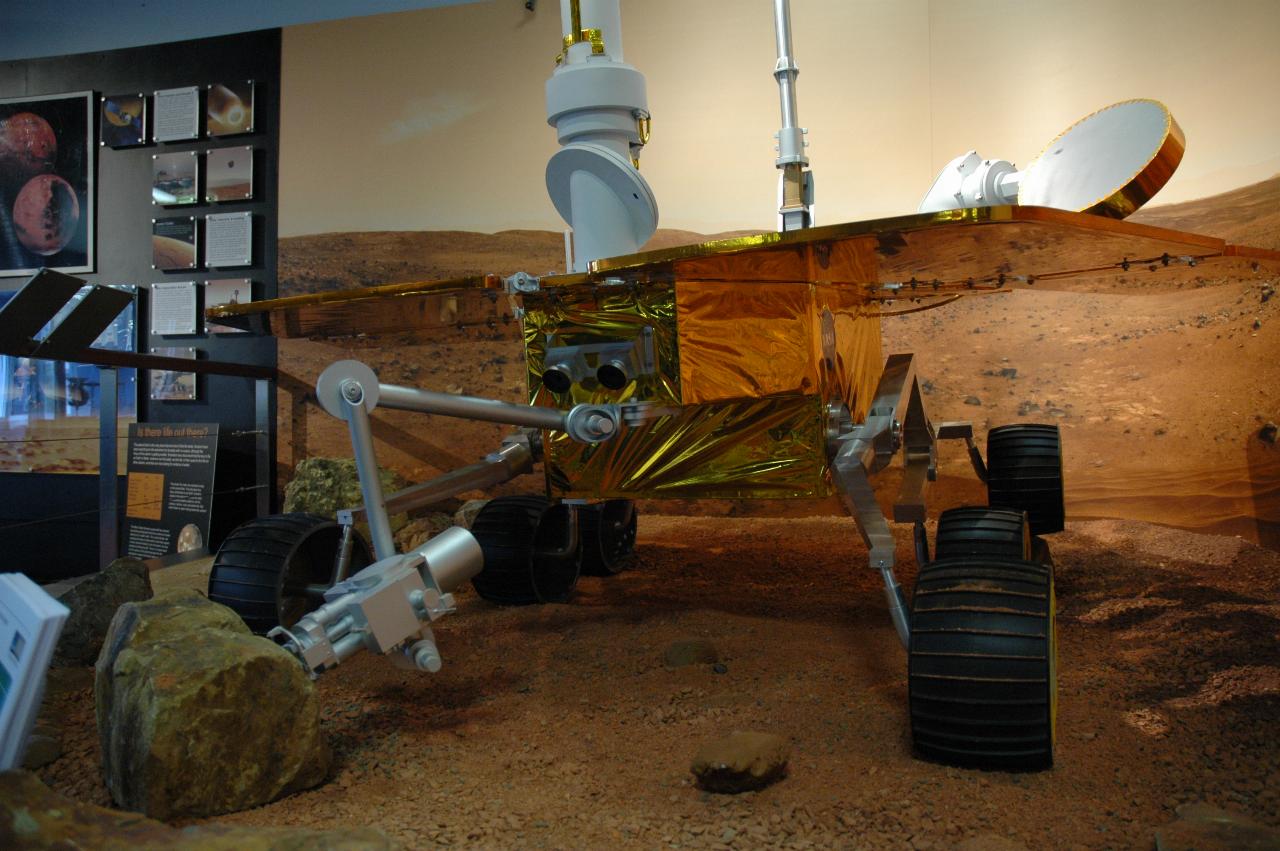 Mars rover in display of simulated surface of Mars; front view from ground level