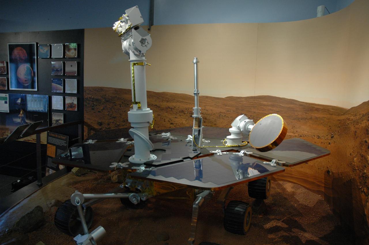 Mars rover in display of simulated surface of Mars; front view