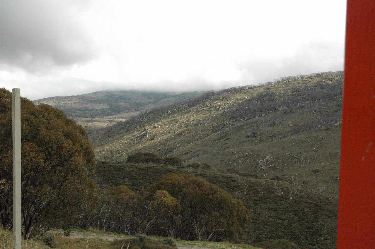 View up valley with rocky, grass covered hill side