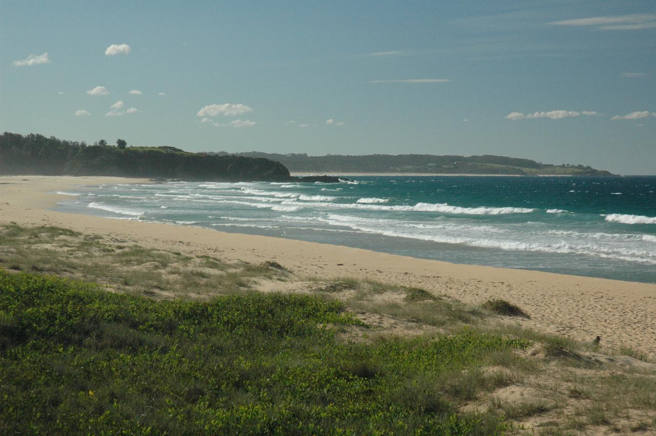 Beach scene with waves and distant headlands